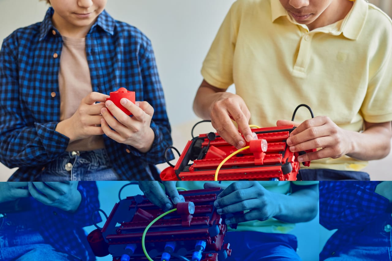 Two young people wiring a red circuit kit with coloured cables