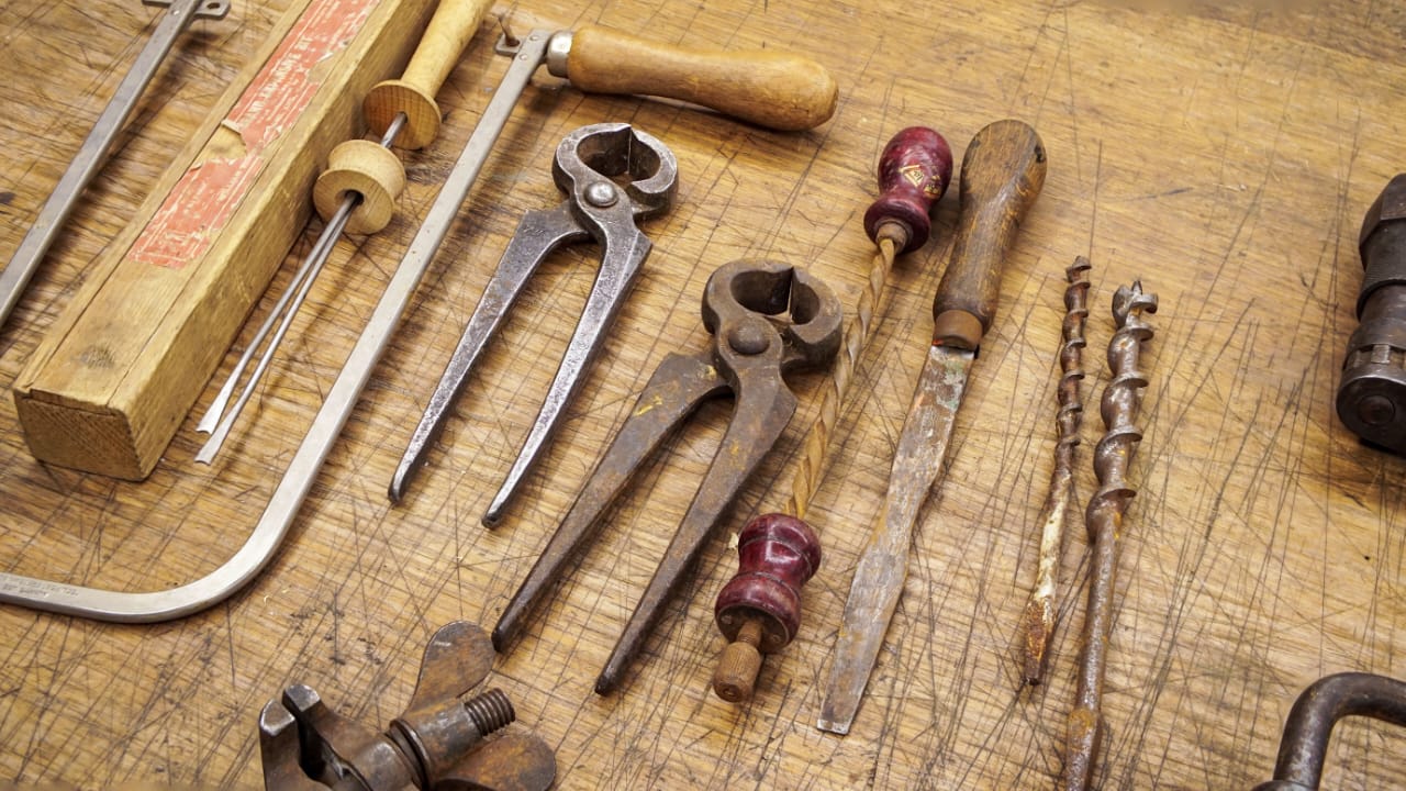 Vintage hand tools laid out on a well-worn wooden workbench
