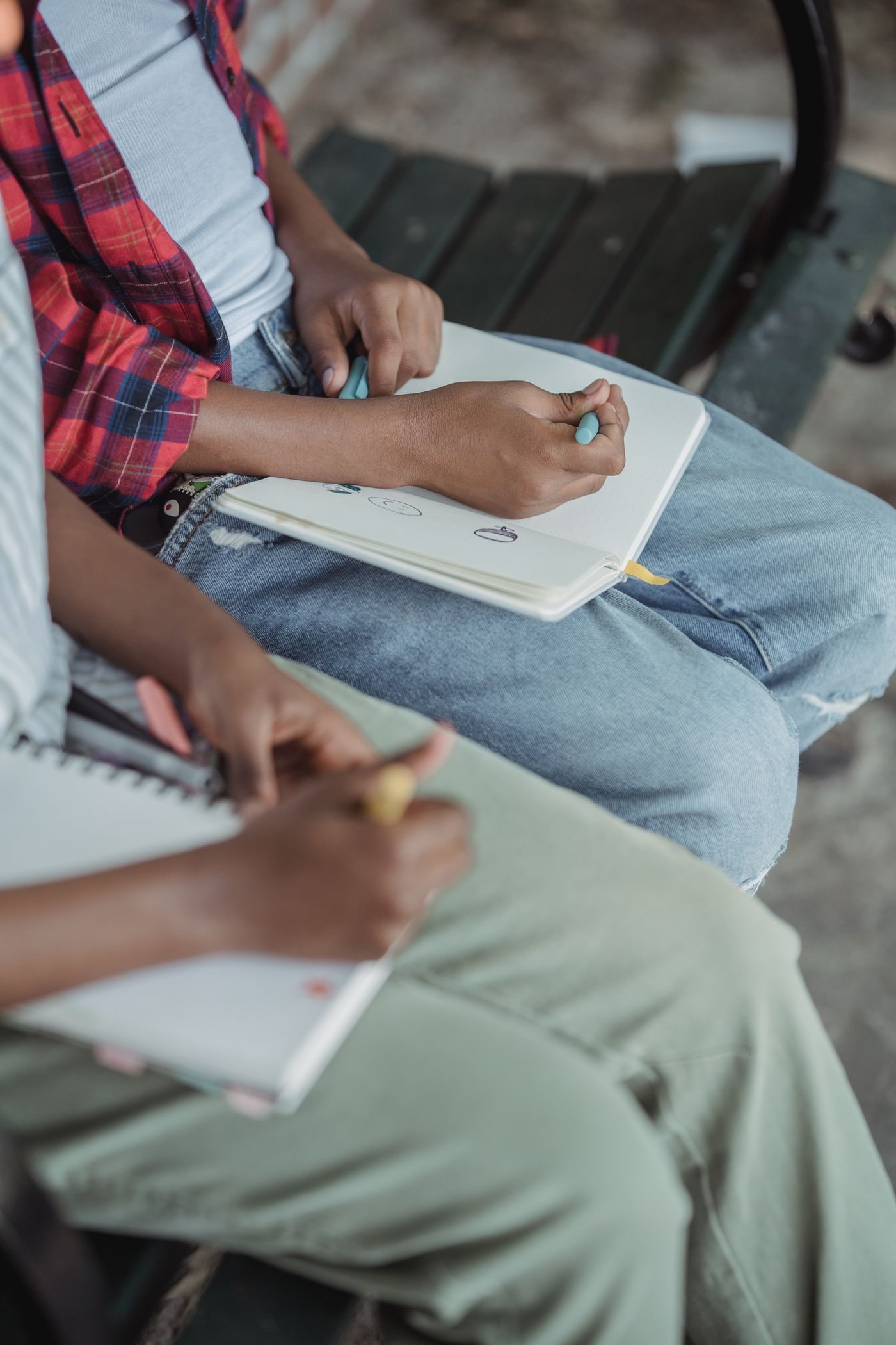 A child sketching in a notebook, pencil in hand, working out an idea on paper